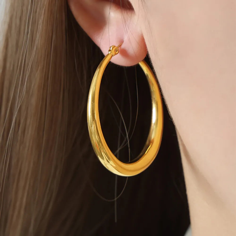 Woman wearing 18K gold-plated stainless steel hoop earrings for everyday wear front view