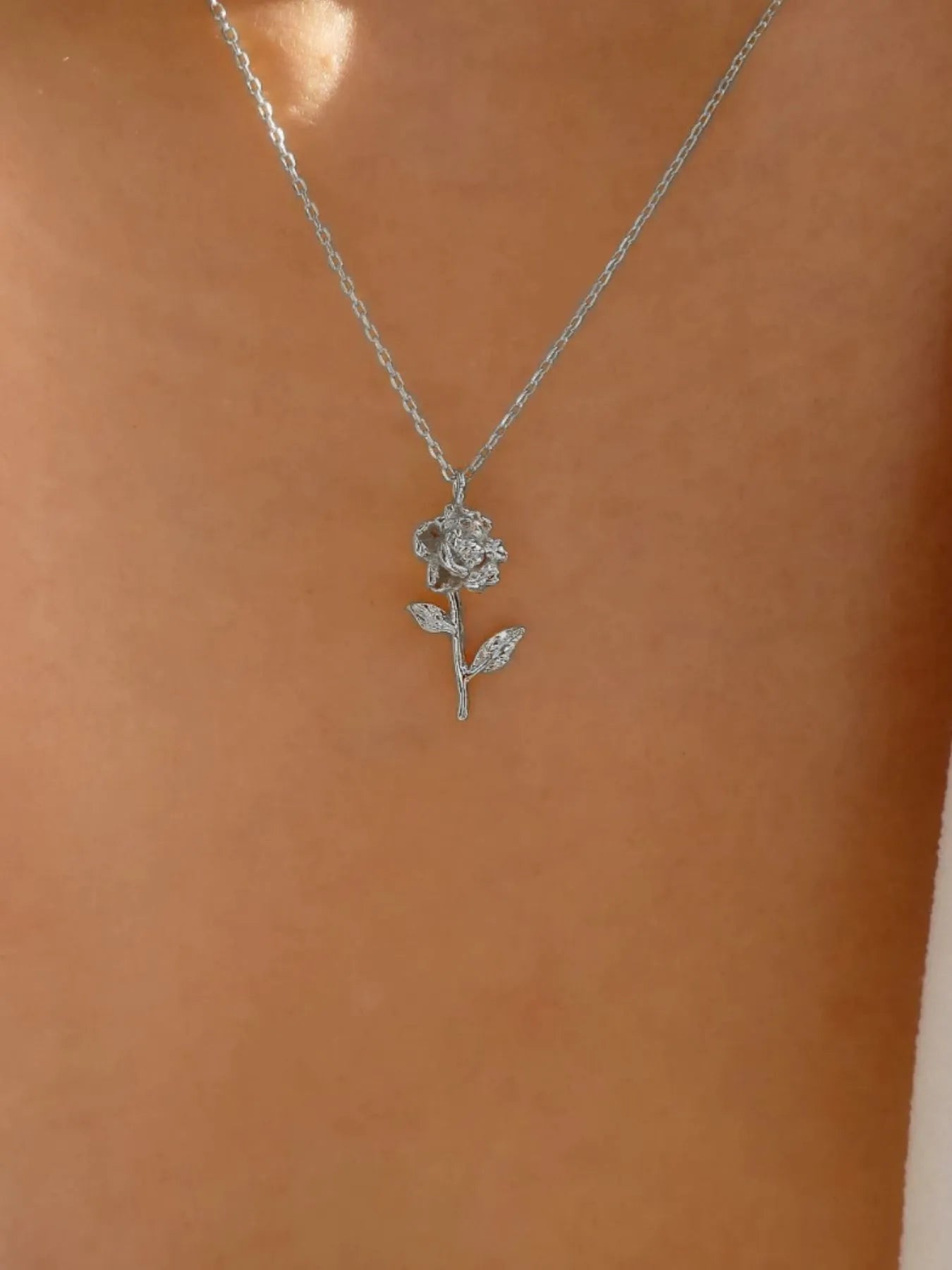 Floral charm necklace with adjustable chain in silver on woman