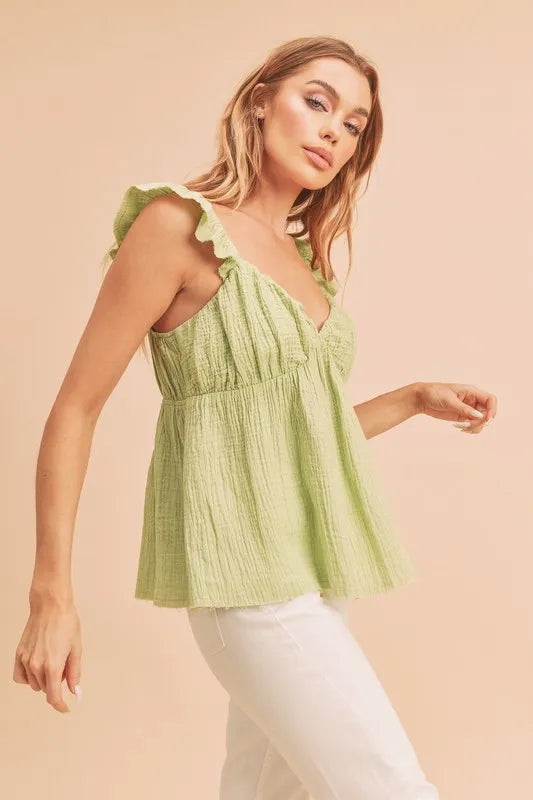 Model wearing sweetheart neck ruffled strap top in fitted flowy silhouette side view