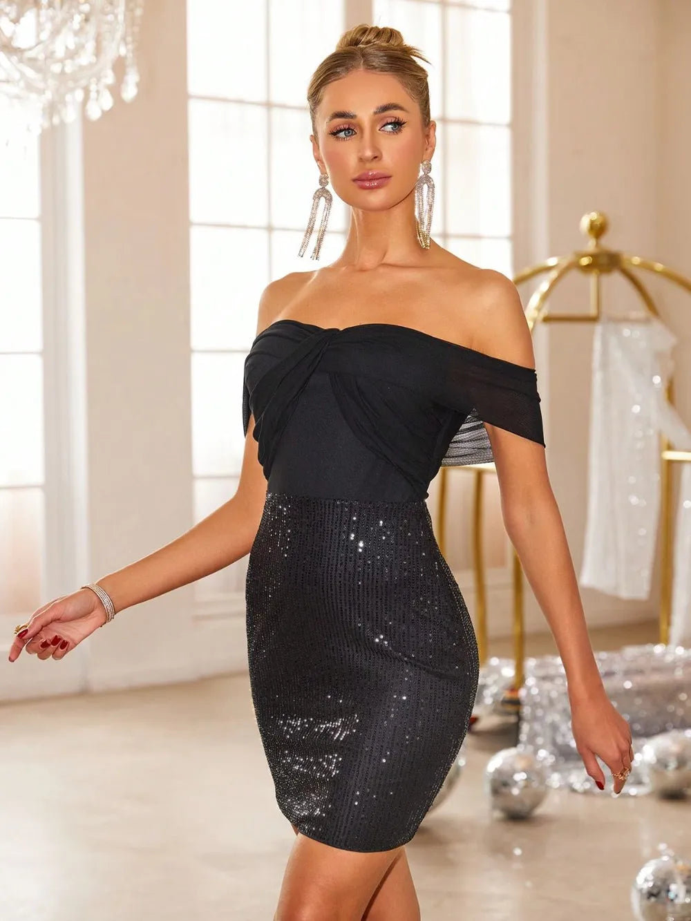 Model wearing black off-shoulder sequin mini dress walking side view