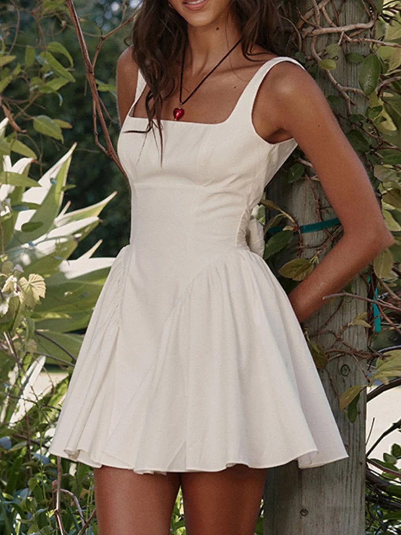 Model wearing white square neck open-back mini dress front view