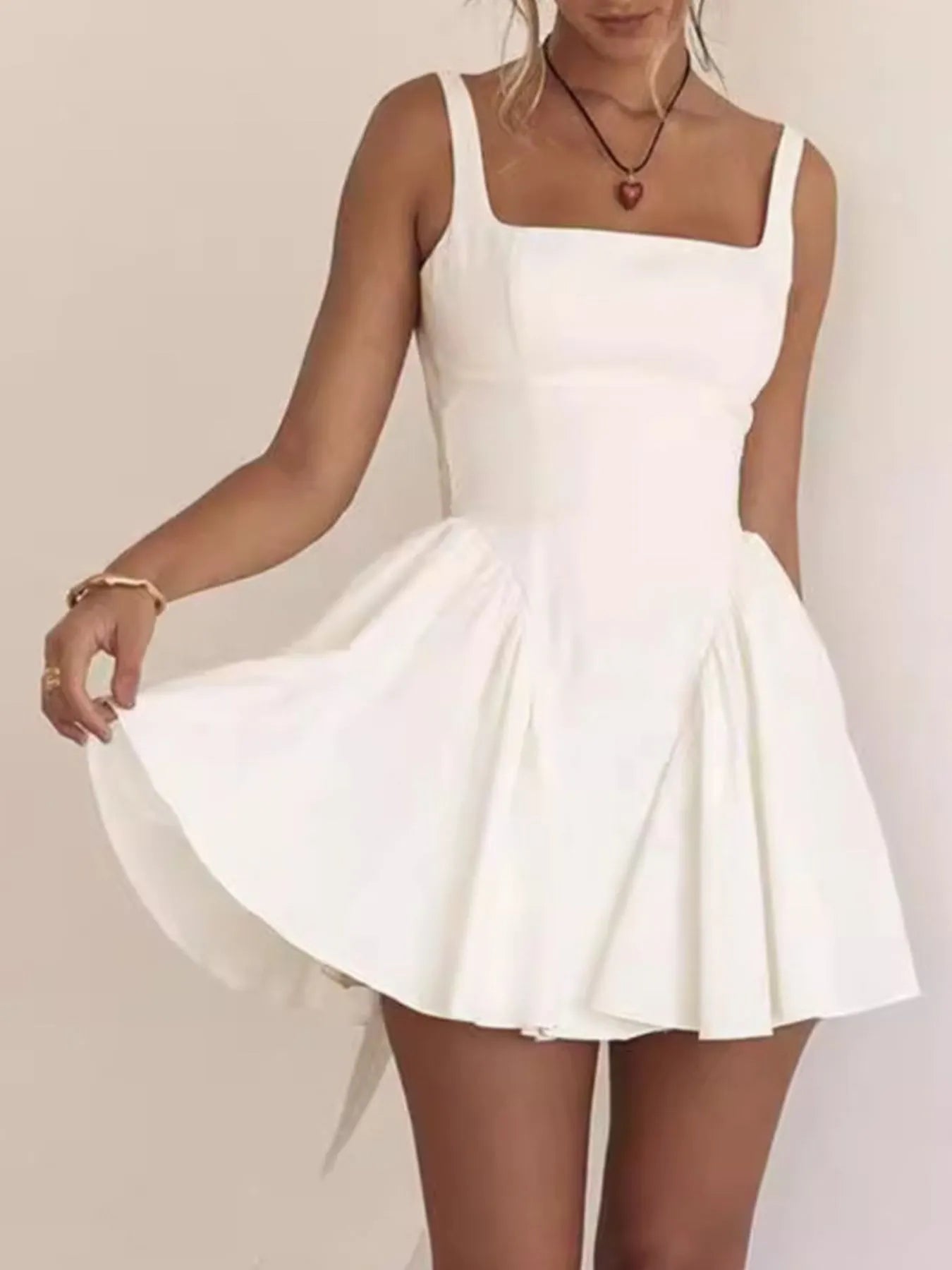 Model wearing white square neck open-back mini dress front view
