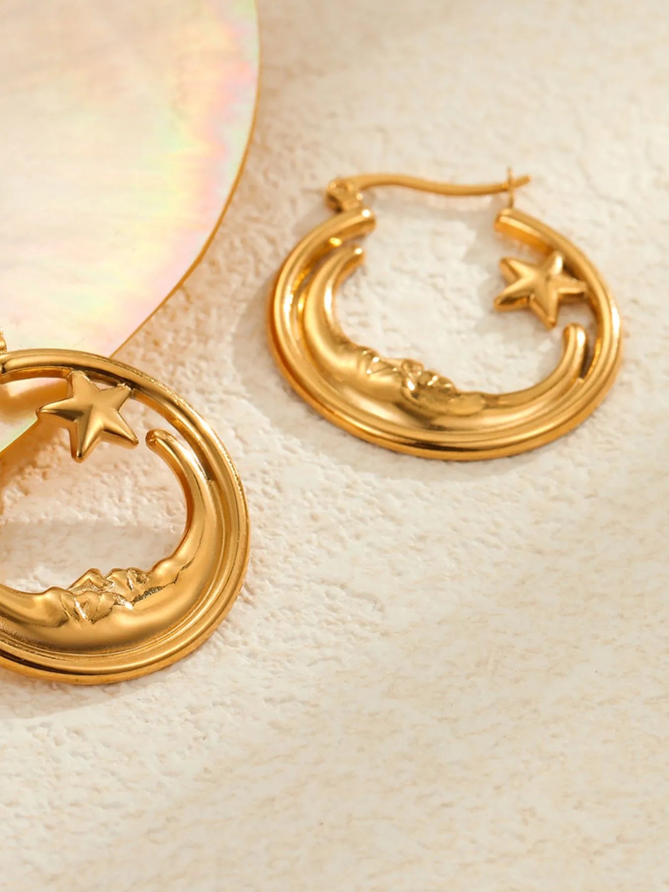 18K gold plated moon and star charm hoop earrings on flat surface