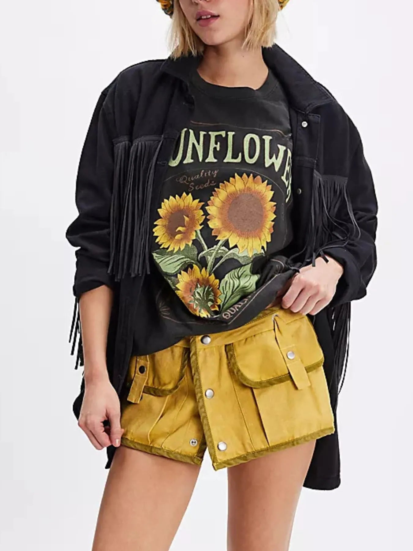 Woman wearing a black short sleeve T-shirt with sunflower design and yellow shorts.