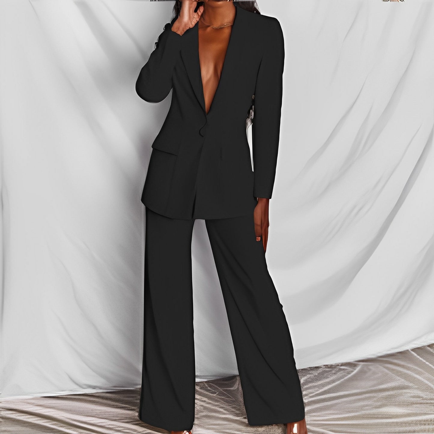 Woman modeling a black elegant long sleeve blazer and matching trousers suit set for office wear.