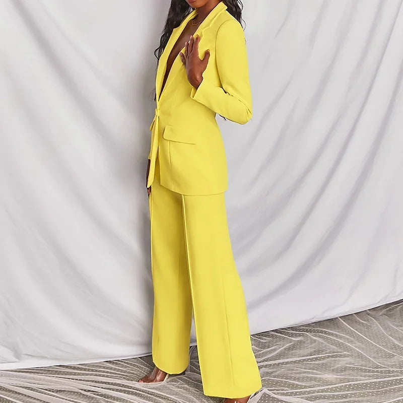Woman modeling a yellow elegant long sleeve blazer and matching trousers suit set.
