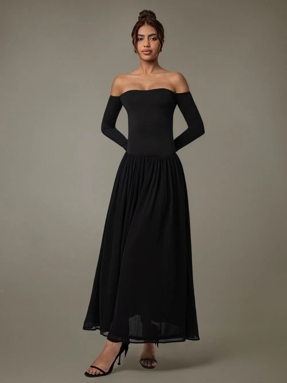 Model wearing off-shoulder long sleeve maxi dress in soft neutral tone background