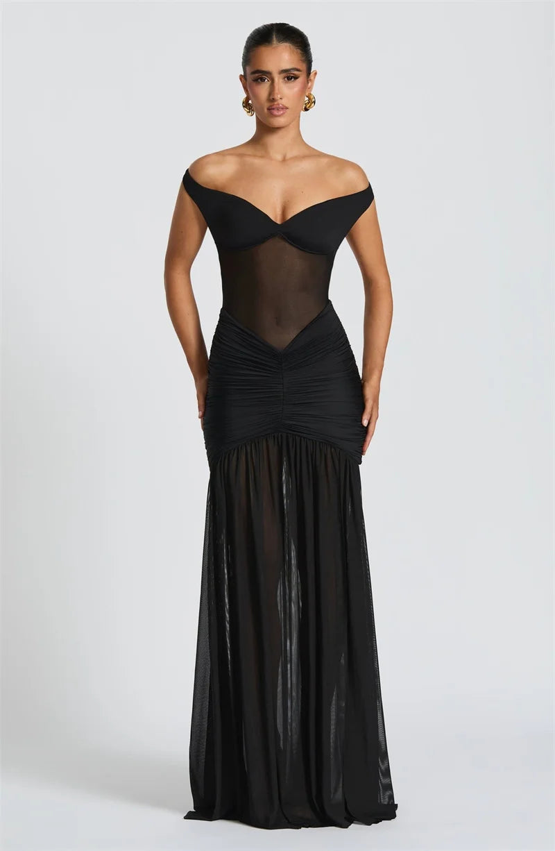 Woman in a black off shoulder backless high thigh slit evening formal dress with flowy hem
