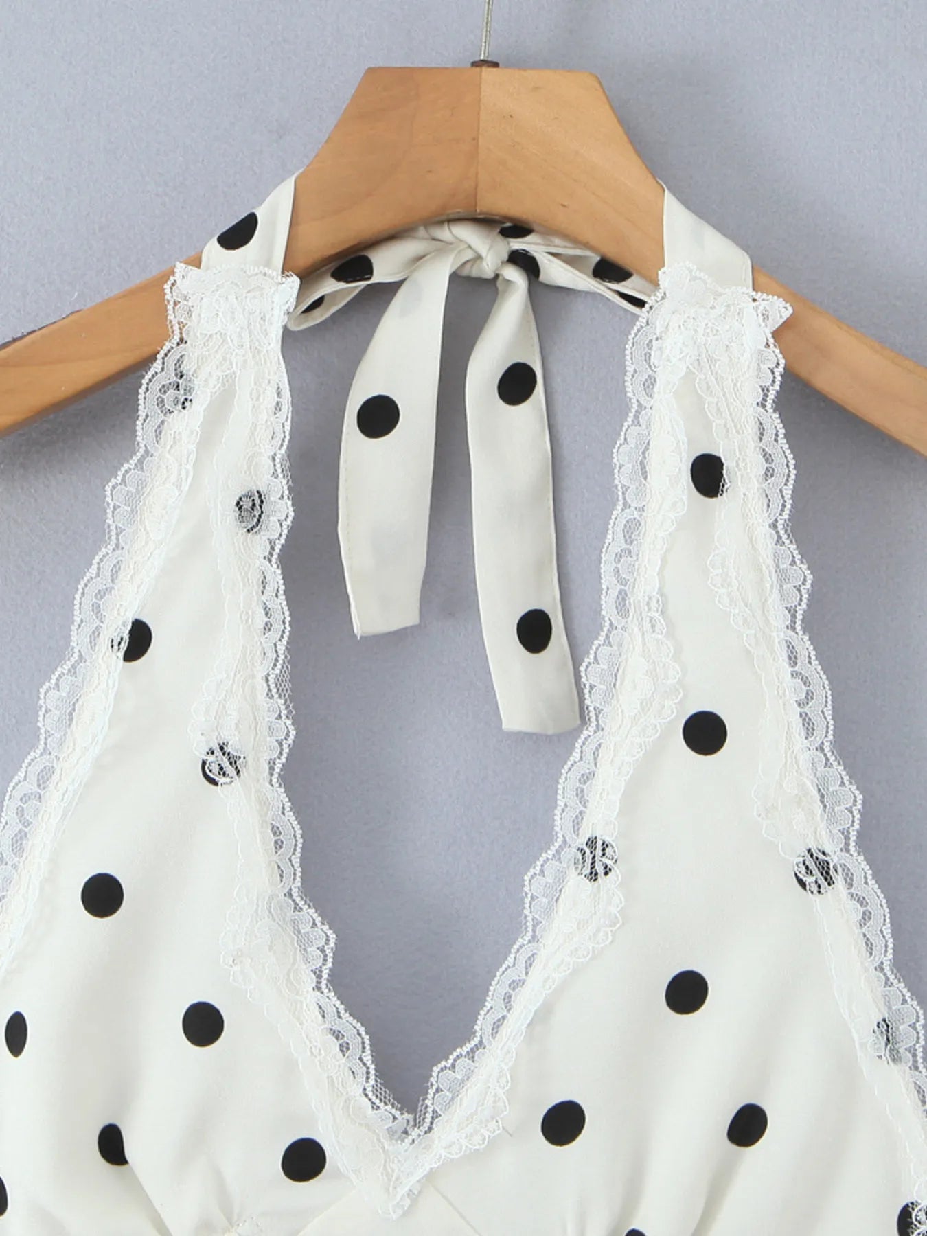 Close-up of lace trim at neckline of polka dot halter mini dress