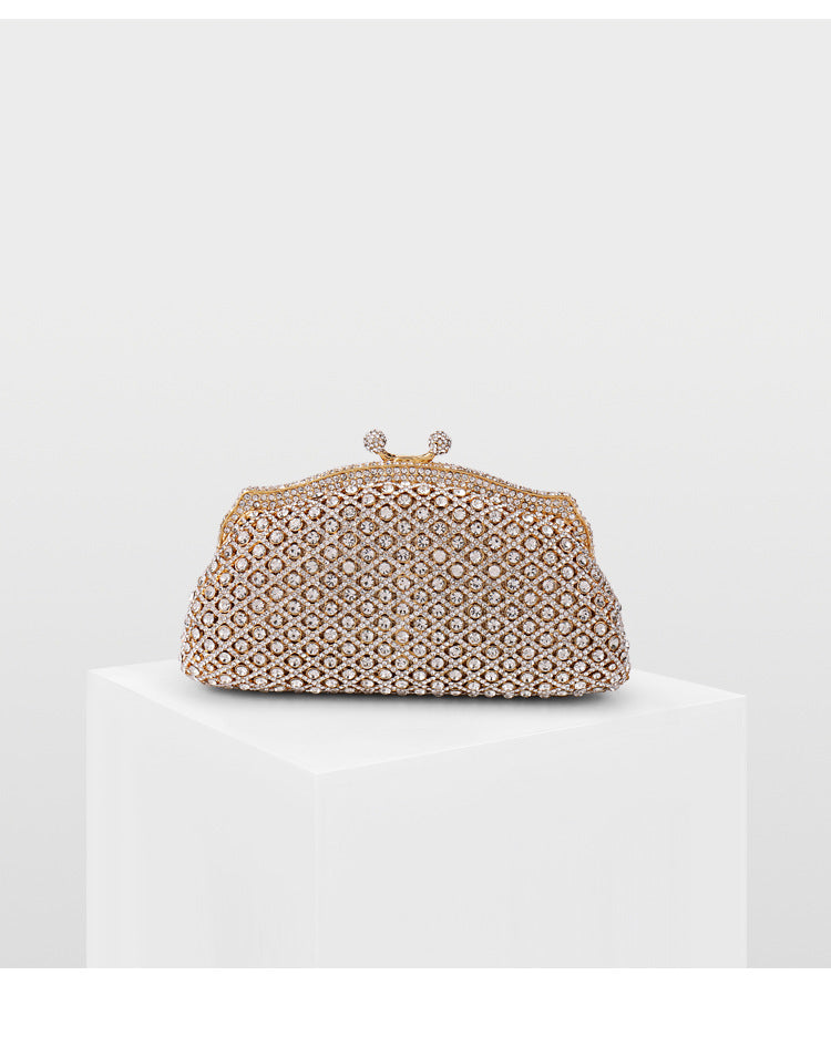 Glamorous gold vintage-style evening bag with rhinestone embellishments on a white backdrop