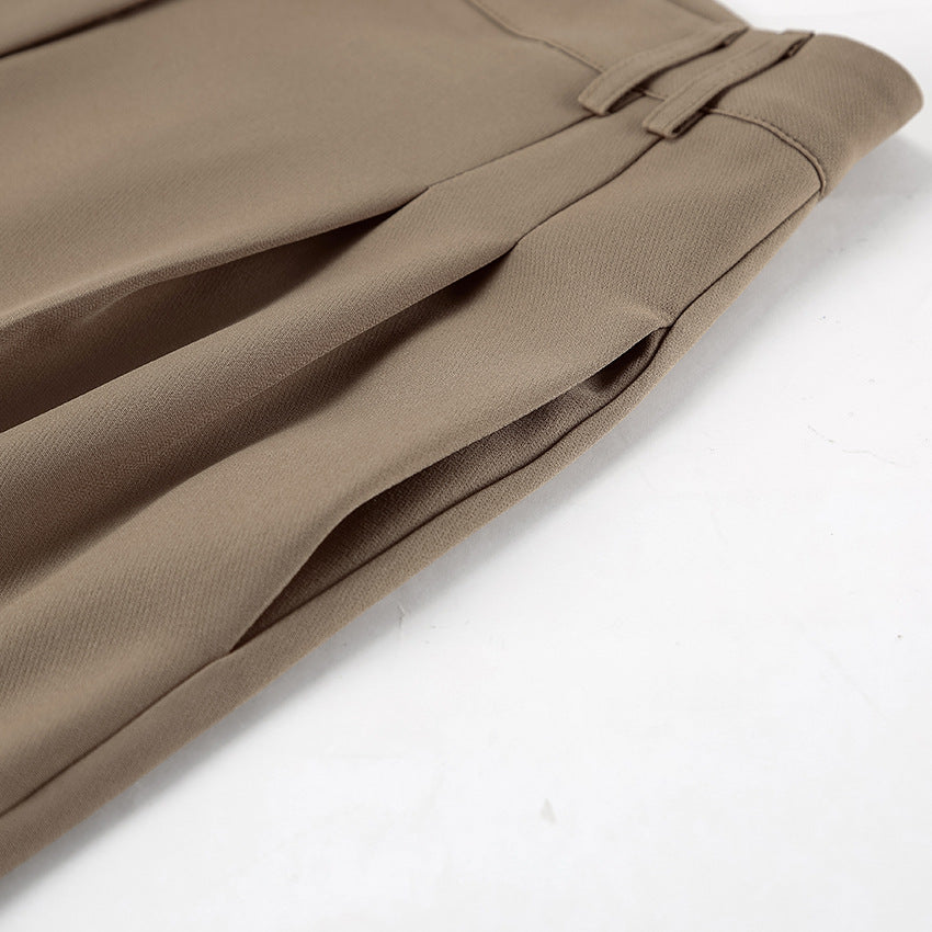 Close-up of side pockets for brown pants suit set on a white background