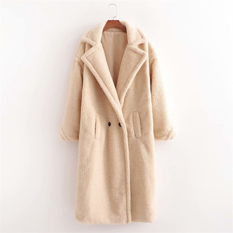 A long beige/cream/ivory plush teddy coat with long sleeves, front buttons and pockets displayed on a hanger against a white background.