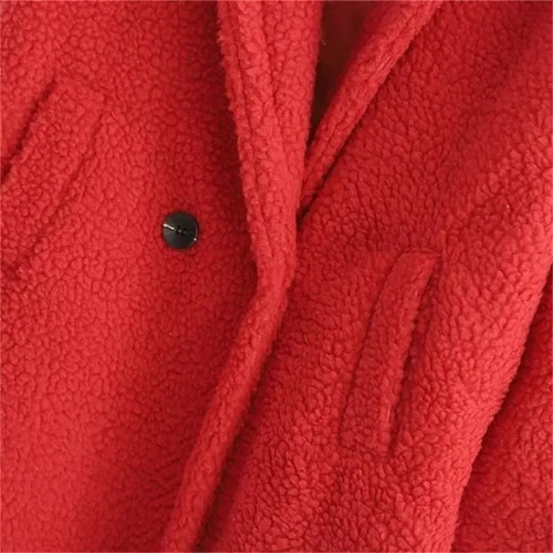 Close-up of button and pockets of a long red plush teddy coat showing texture