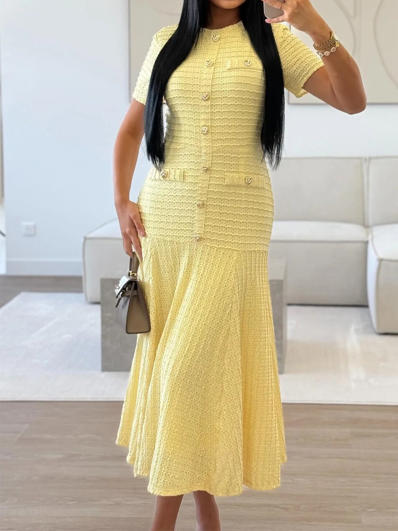 Woman wearing a yellow Textured Knit Short Sleeve Midi Dress in a modern living room.