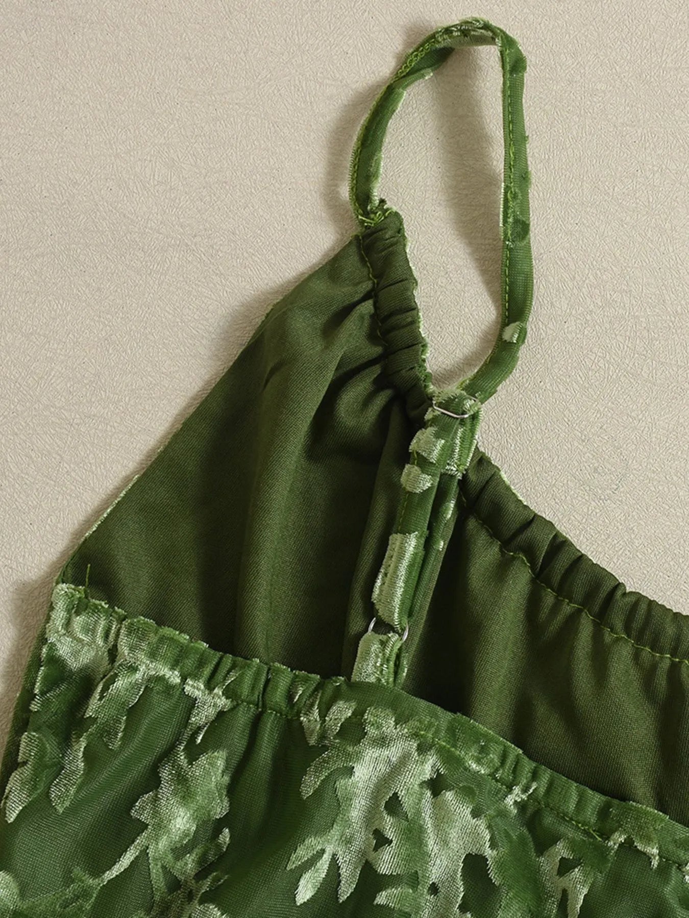 Green textured cami midi dress adjustable straps close up-trimmed top on a beige background