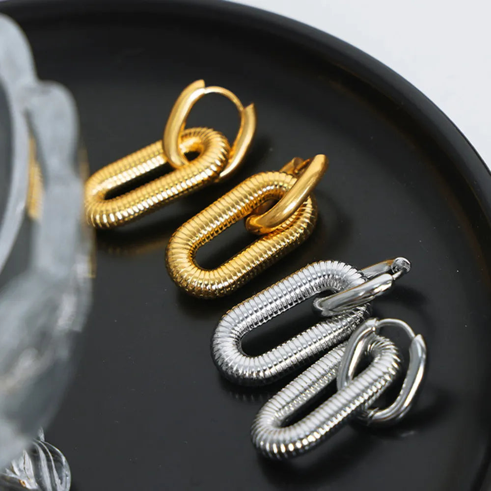 Pair of 18K Gold plated and silver titanium steel hypoallergenic dangle earrings on a black plate