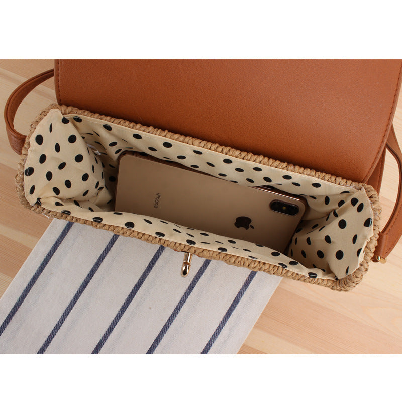 Open brown woven straw handbag with polka dot lining on a wooden surface