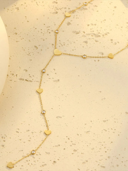 18K gold plated heart zircon necklace with crystal charm on cream surface