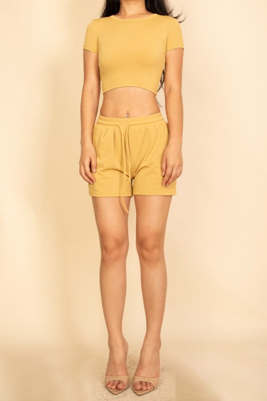 woman wearing a yellow ribbed two piece crop tee and drawstring shorts loungewear front view