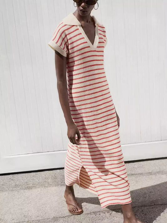 Woman wearing a red and white striped dress against a white wall.