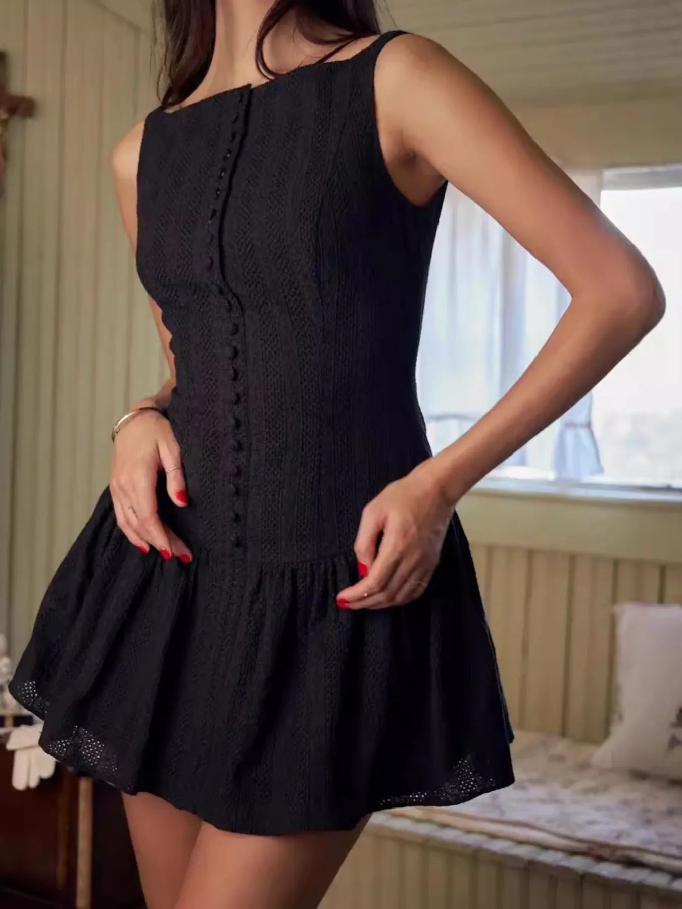 Model wearing black sleeveless lace bodycon mini dress in white side view
