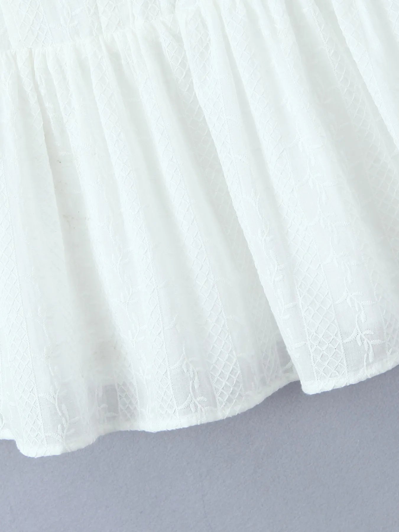 Close-up of lace mini dress in white hem and fabric texture 