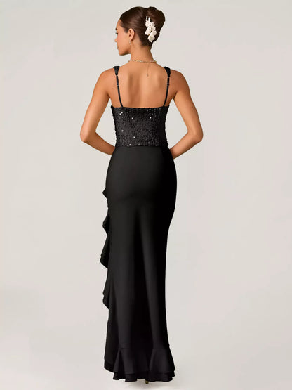 Woman wearing a black evening gown with sequin detailing top and ruffled skirt on a white background back view