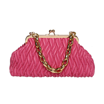 Pink textured leather handbag with a gold chain handle on a white background