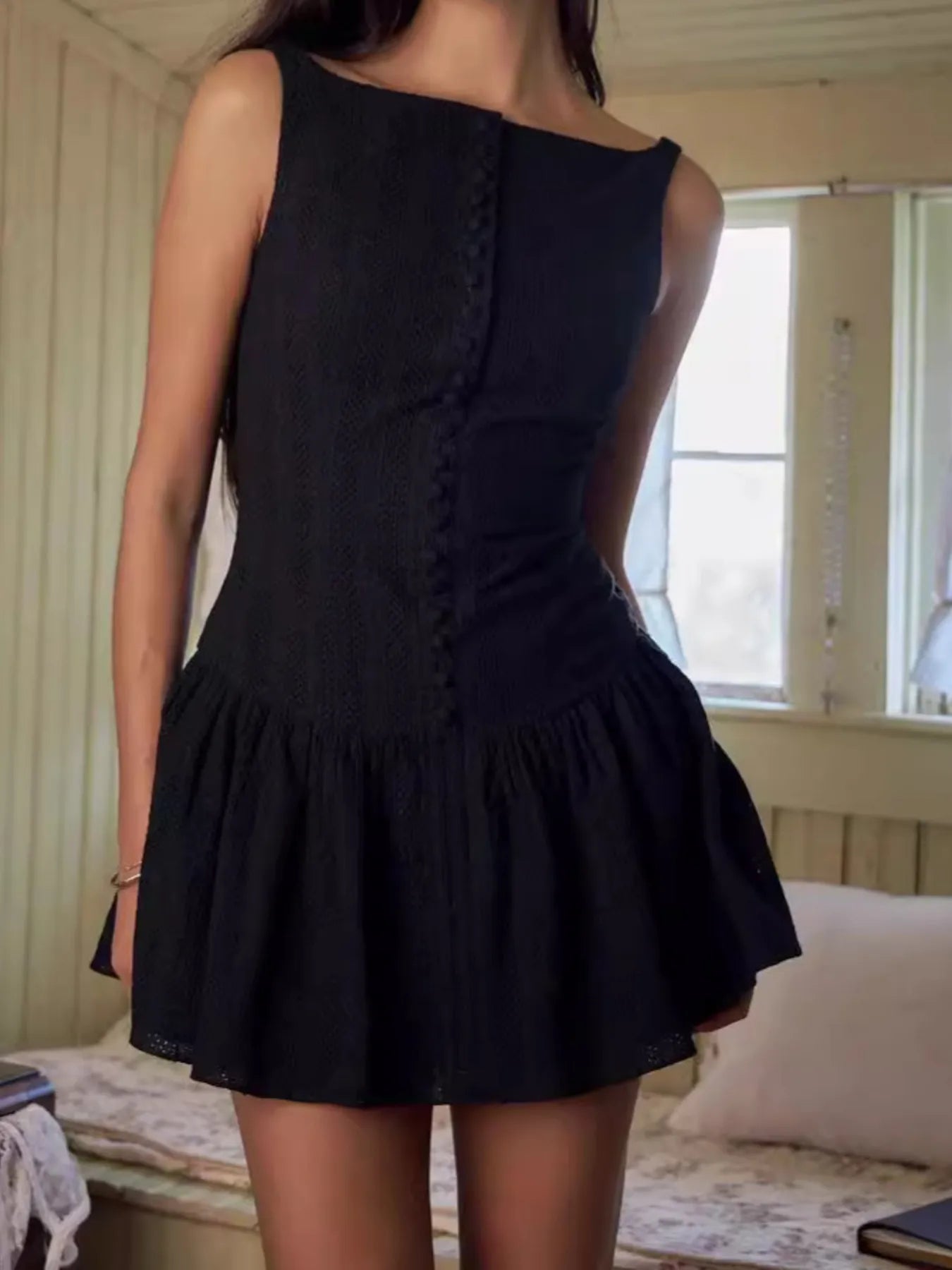 Model wearing black sleeveless lace bodycon mini dress in white front view
