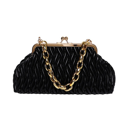 Black textured clutch leather handbag with gold chain and frame on a white background