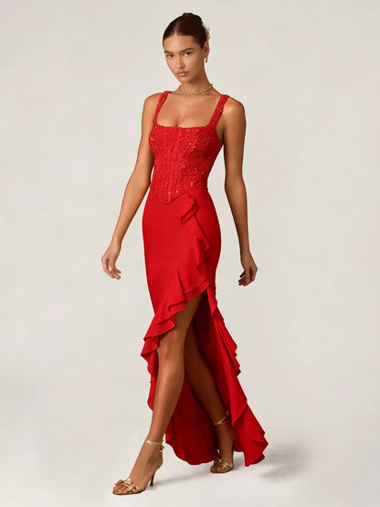 Woman wearing a red evening gown with sequin detailing top and ruffled skirt on a white background front view