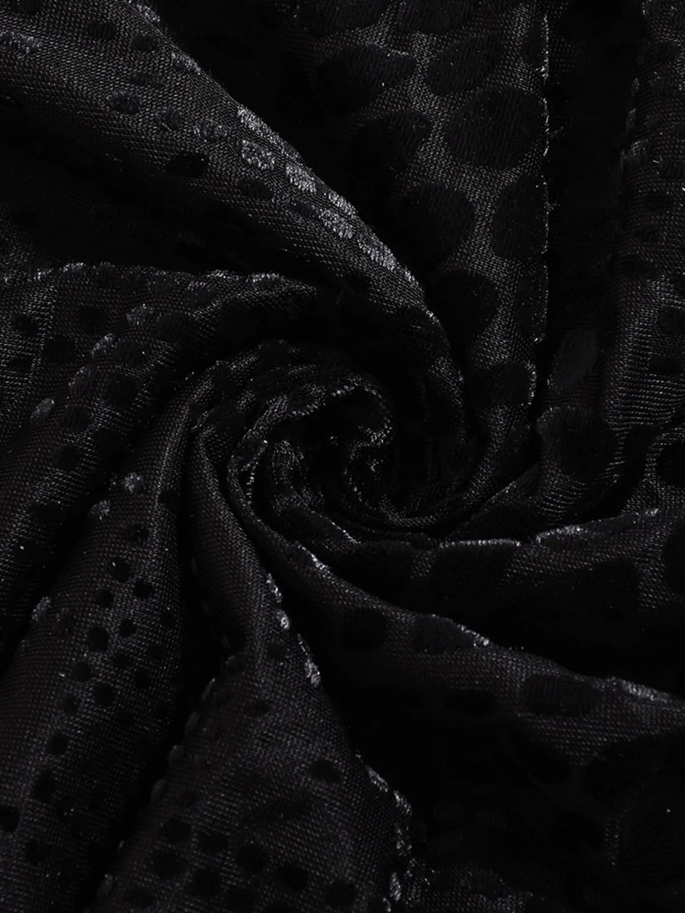 Close-up of black fabric for open back mini summer dress with a subtle pattern
