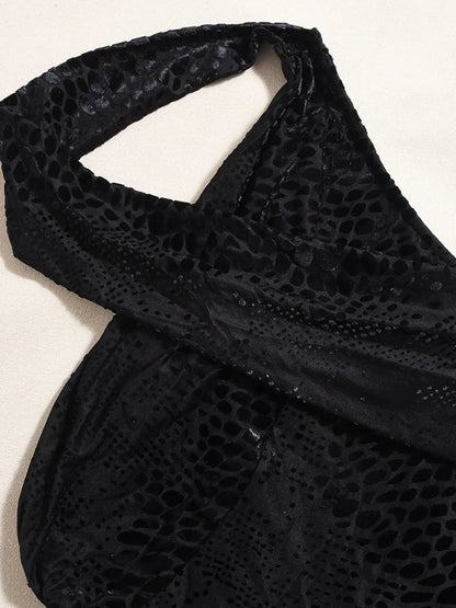 Close up of Black halter asymmetrical halter mini dress neckline on a light background