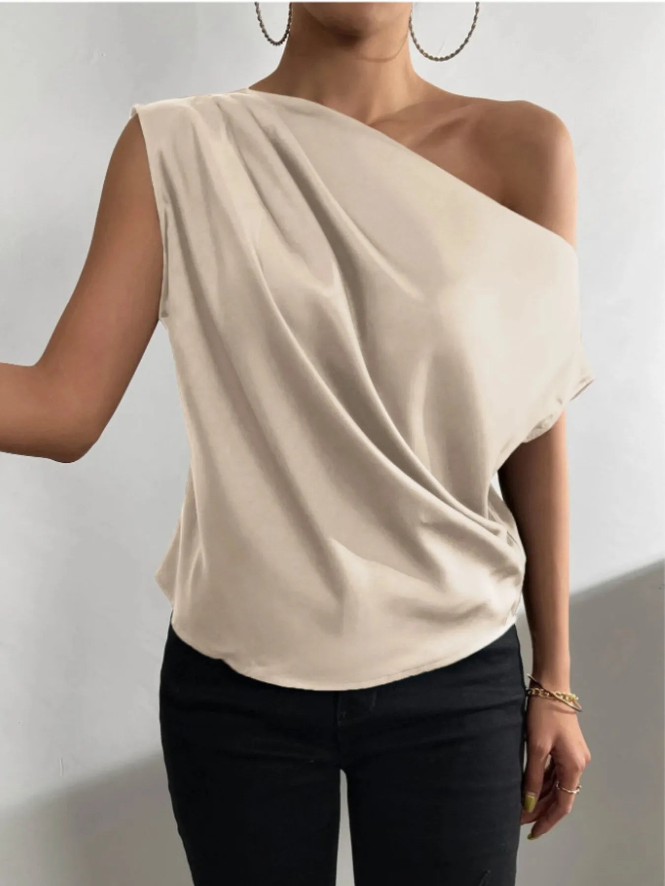 front view of Beige  satin Asymmetrical One-Shoulder Draped Blouse worn by a woman on a plain background