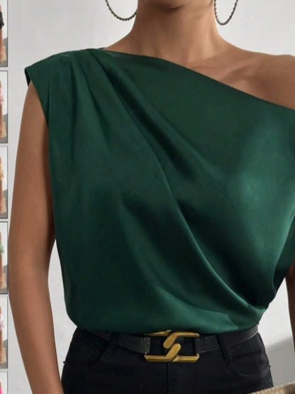 Woman wearing a Green Asymmetrical One-Shoulder Draped Blouse with belted high waist pants with a blurred background