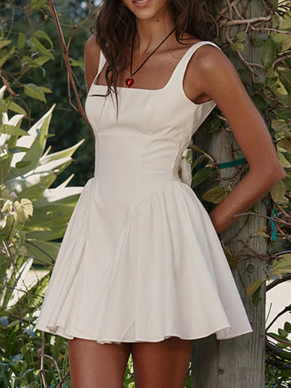 Model wearing white square neck open-back mini dress front view
