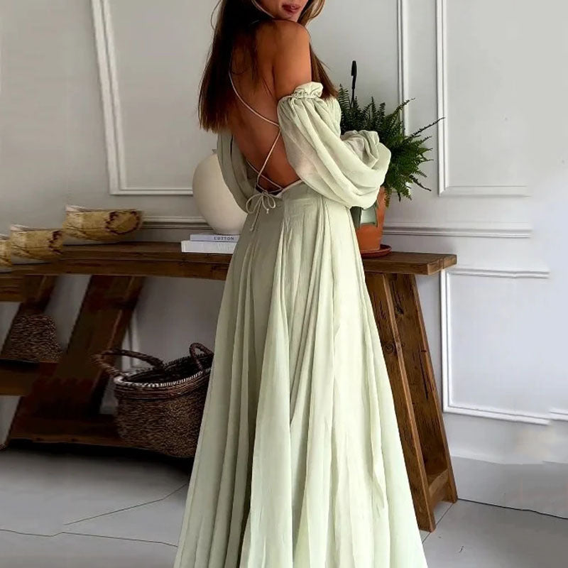 back view of flowy light green / sage flowy off shoulder cut out detail backless maxi dress in an indoor room