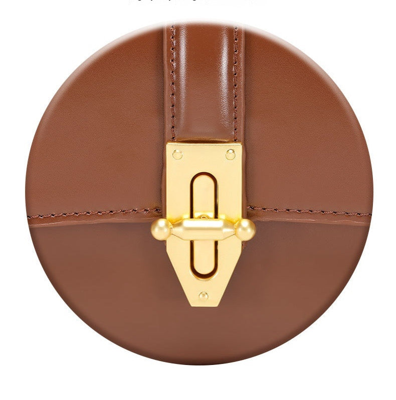 Close up of gold clasp  of genuine leather shoulder baguette bag on a white background