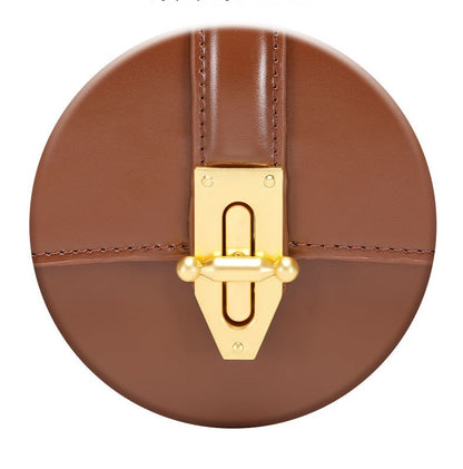 Close up of gold clasp  of genuine leather shoulder baguette bag on a white background