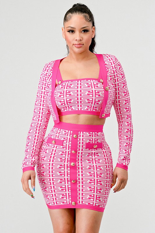 Model wearing pink printed three-piece bandage set with long sleeve top, crop, and skirt front view