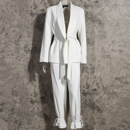 Front view of a high-fashion women’s white tailored blazer pants suit set on a mannequin on a gray background