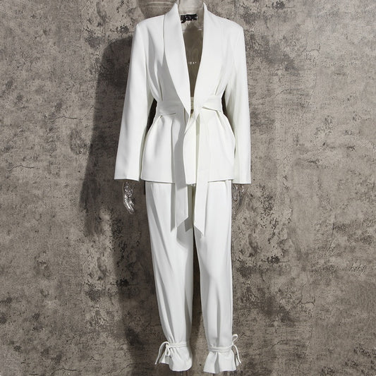 Front view of a high-fashion women’s white tailored blazer pants suit set on a mannequin on a gray background