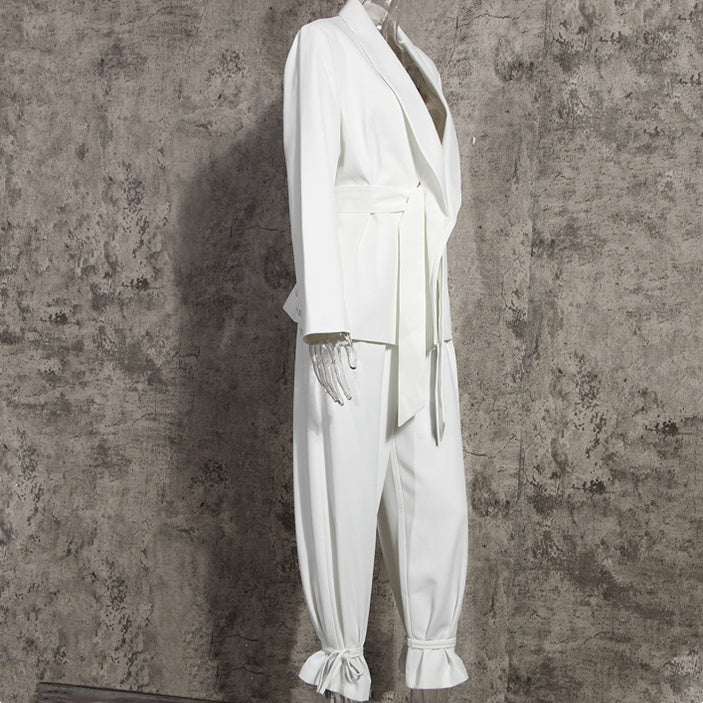 Side view of a high-fashion women’s white tailored blazer pants suit set on a mannequin on a gray background