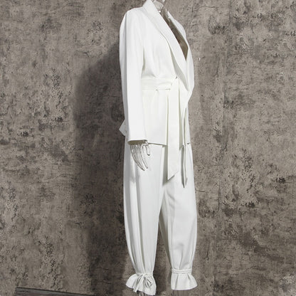 Side view of a high-fashion women’s white tailored blazer pants suit set on a mannequin on a gray background