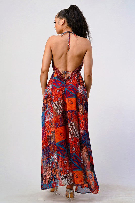 back view of woman wearing a luxury bohemian sequin lace maxi dress with plunging halter neckline and flowing silhouette
