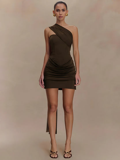 Woman wearing a brown draped one-shoulder mini dress on a beige background front view