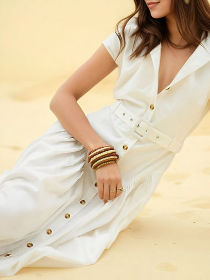 Woman wearing a white button front belted midi shirt dress laying down