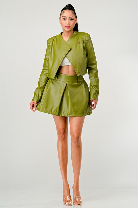 Front view of woman wearing a green high-fashion streetwear PU leather co-ord on a white background