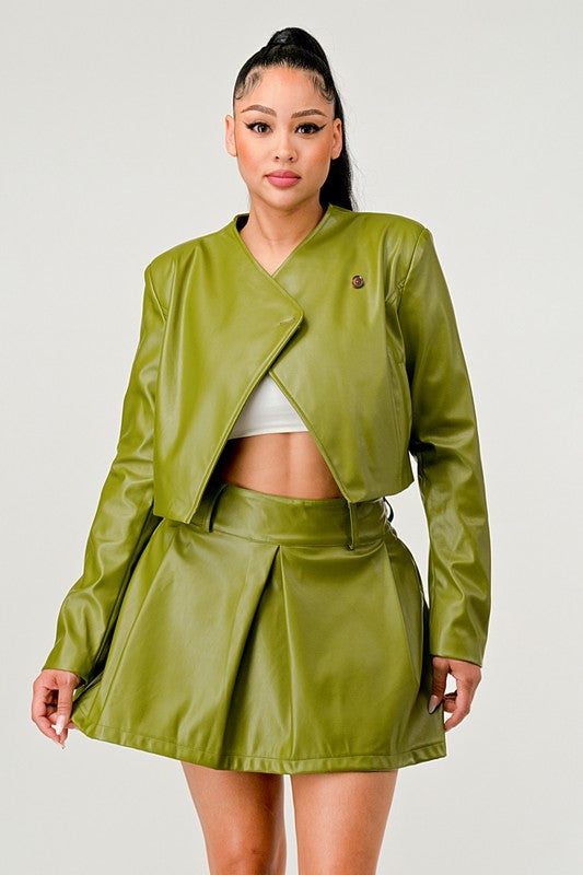 Front view of woman wearing a olive green PU leather jacket and skirt set on a white background