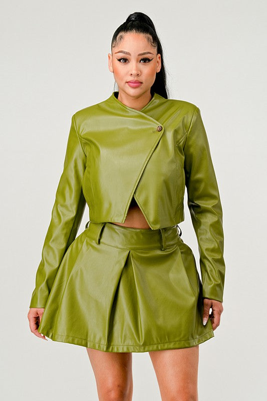 Close up of woman wearing a green luxury vegan leather two-piece outfit on a white background